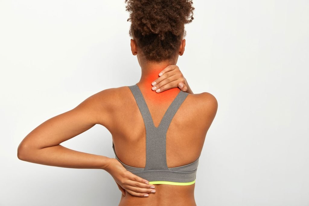Fit woman suffers from neck pain.