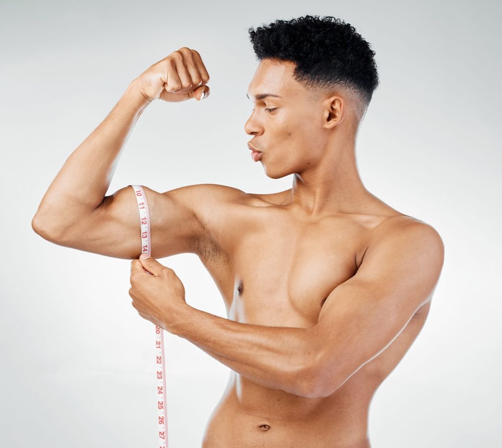 Muscular man measuring his bicep.