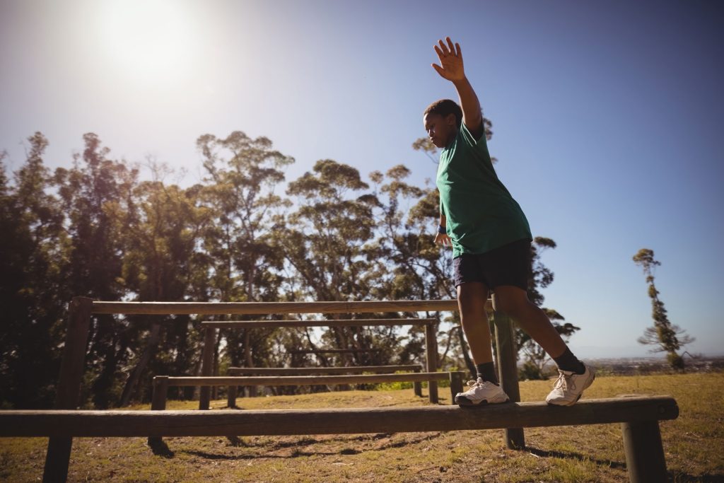 Young boy balancing in a playground.