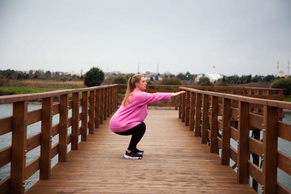 Woman doing a squat exercise outdoor.