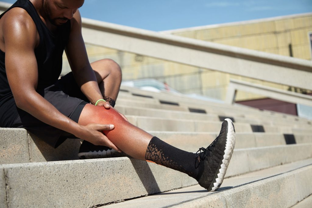 Fit man holding his knee.