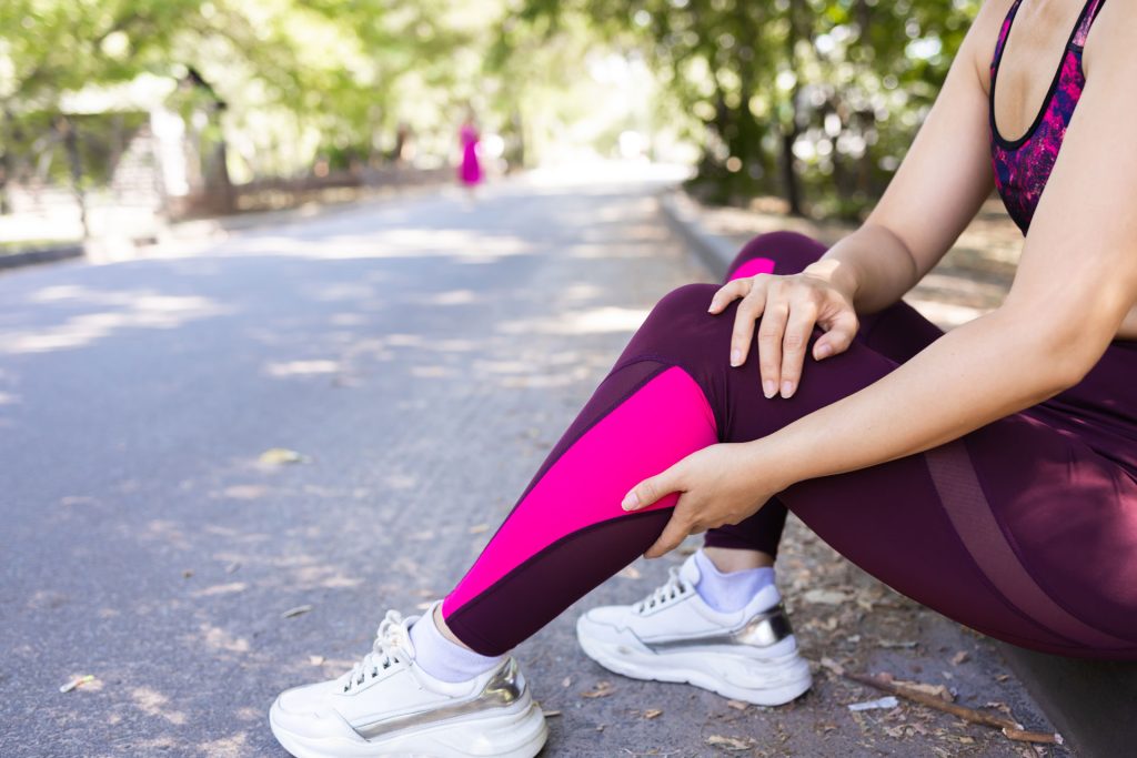Young woman with muscle cramps in calves.
