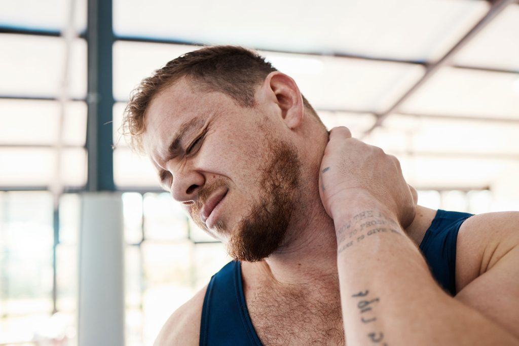 Fit man with neck pain.