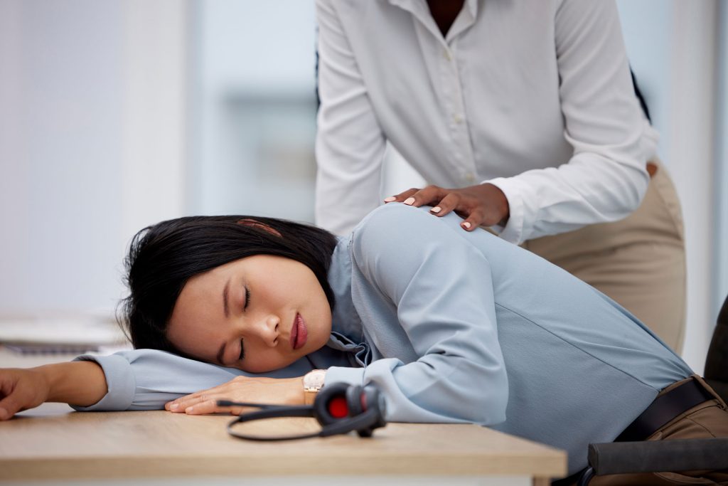 Asian with Chronic Fatigue Syndrome sleeping on her desk.