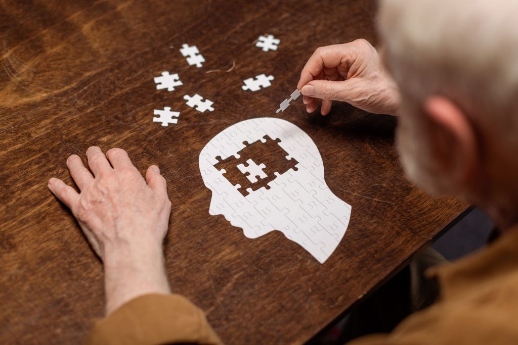 Senior man collecting jigsaw puzzle.