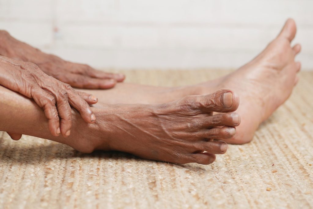 Close-up photo of senior feet and hand.