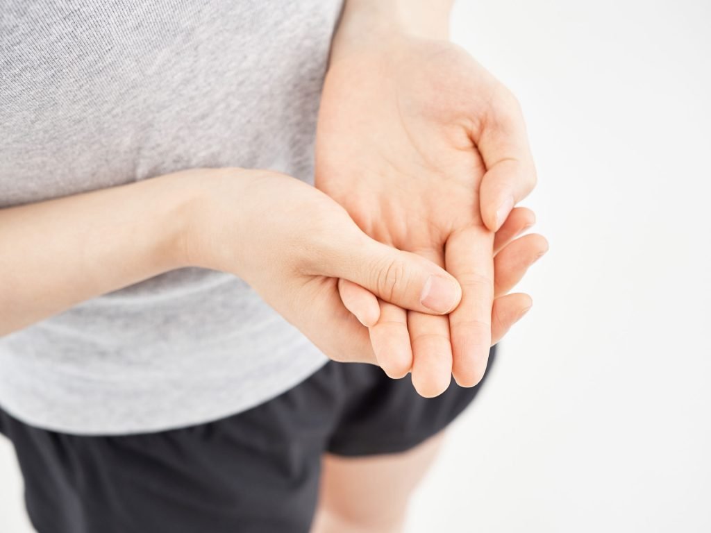 Woman holding her sore hand.
