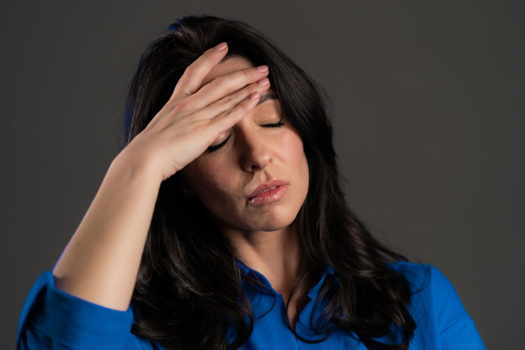 Dizzy woman touching her forehead.