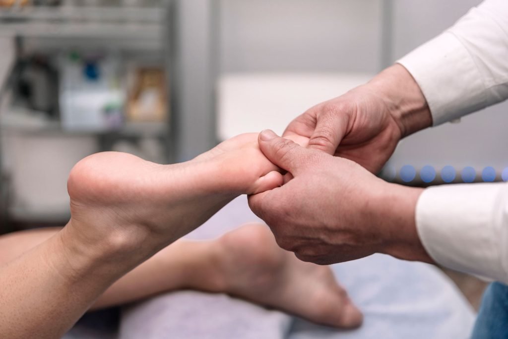 Therapist hands massaging a foot.